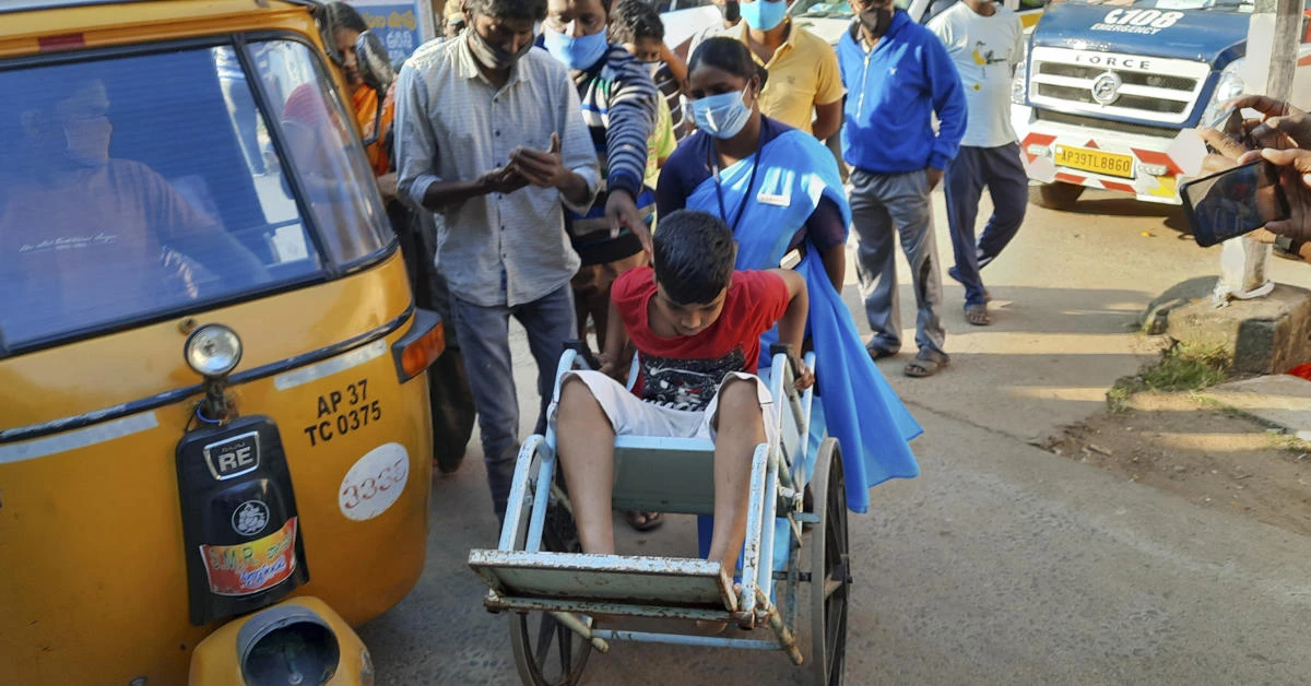 A young patient is brought in a wheelchair to the district government hospital in Eluru, Andhra Pradesh state, India, Sunday, Dec.6, 2020. (AP Photo)
