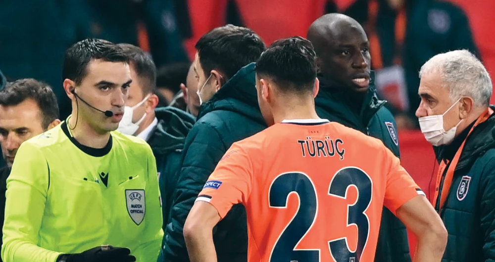 Referee Ovidiu Hategan, left, talks to Istanbul Basaksehir FK coaches and players during the UEFA Champions League game against Paris Saint-Germain, Paris. (AFP)