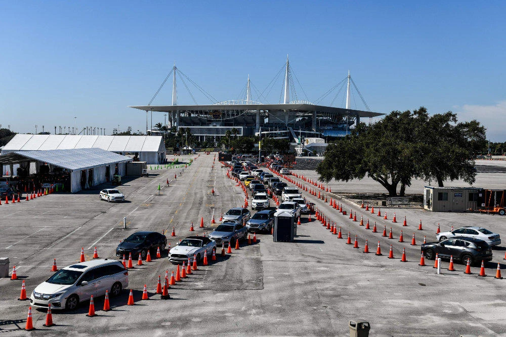 People wait inside vehicles at a drive-through COVID-19 testing site at Hard Rock Stadium in Miami, Florida on December 10, 2020. (AFP / CHANDAN KHANNA)