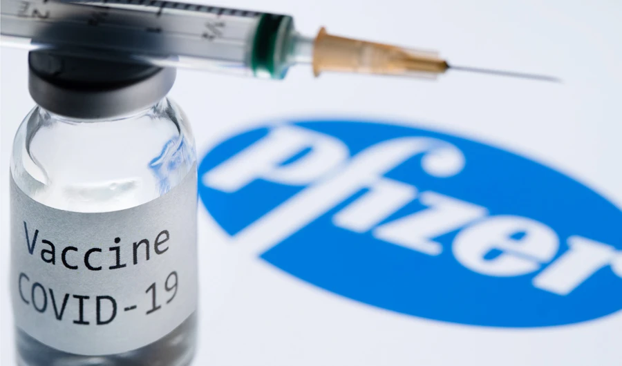 In this file photo illustration taken on November 23, 2020, shows a syringe and a bottle reading "Covid-19 Vaccine" next to the Pfizer company logo. (AFP)