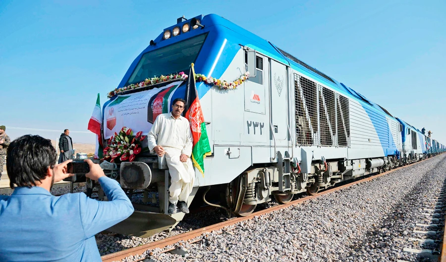 A man gets his picture clicked in front of the first cargo train upon its arrival from Iran during the official inauguration ceremony of Khaf-Herat railway network in Ghoryan district of Herat on December 10, 2020. (AFP)