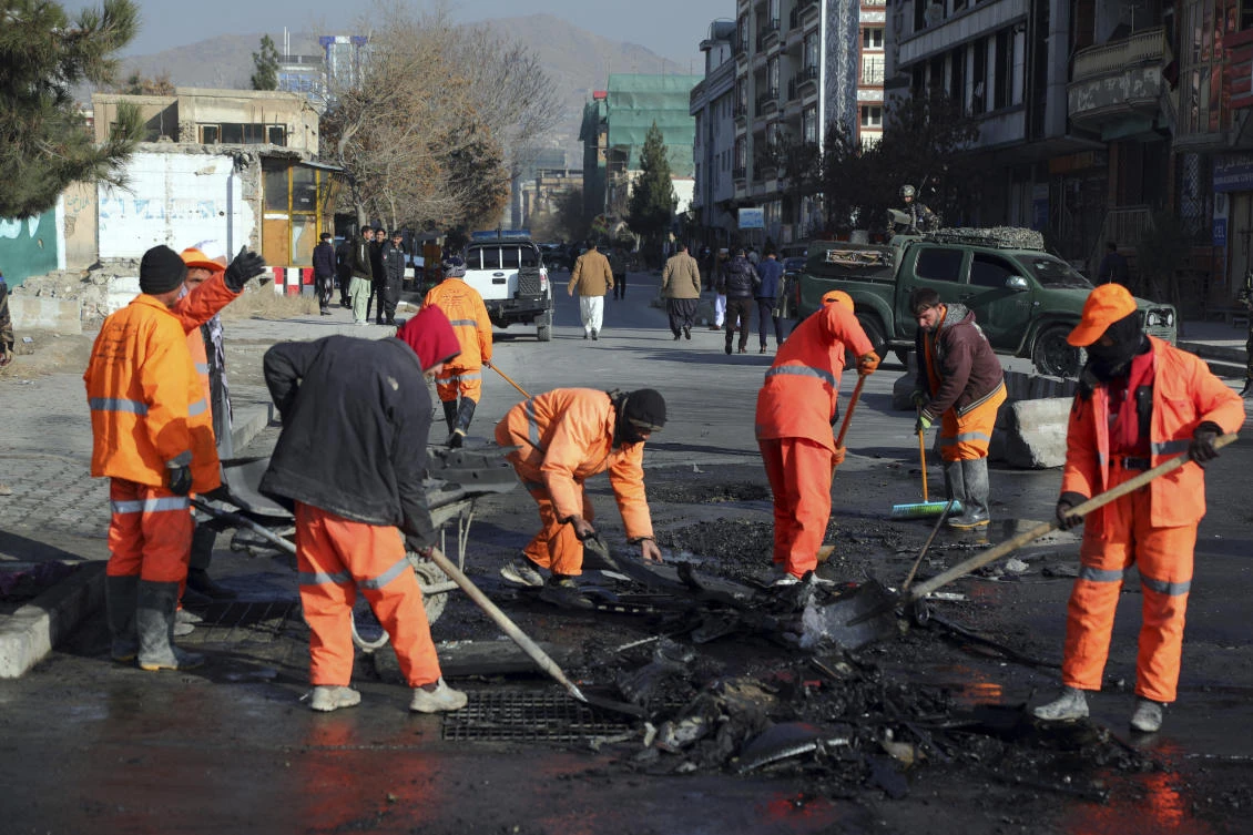 Afghan municipality workers clean the remains of a vehicle after a bomb blast in Kabul, Afghanistan, Sunday, Dec. 13, 2020. (AP)