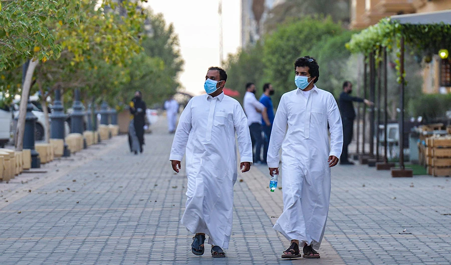 Mask-clad men walk along the promenade of Tahlia street in the centre of Saudi Arabia's capital Riyadh on June 21, 2020. (AFP)