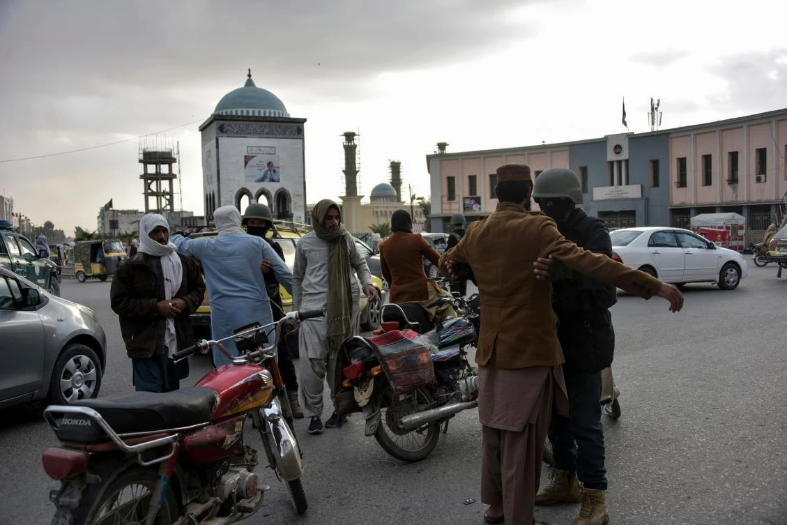 Despite the peace process, violence in Afghanistan has not ended. Above, Afghan policemen search people at a checkpoint at the Chawk-e-Shahidan in Kandahar on Dec. 13, 2020 after overnight violence. (AFP)