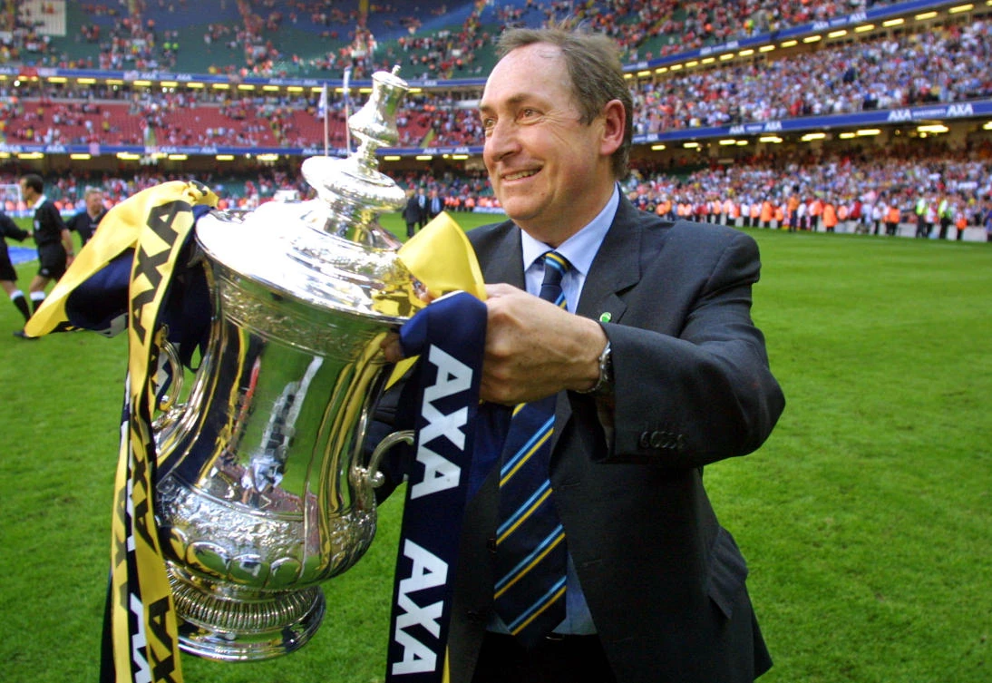 Liverpool’s French Manager Gerard Houllier holds the FA Cup trophy after his team beat Arsenal in the final at the Millennium Stadium in Cardiff, May 12, 2001. (AFP)
