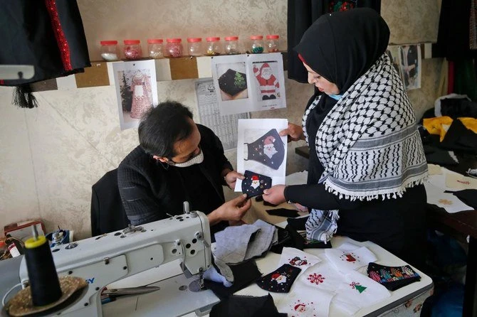 Palestinian Suhad Saidam works with others on Christmas-themed masks in Gaza City on December 9, 2020. Saidam,a 43-years old woman residing west of Gaza city, sews colourful face masks depicting Christmas related symbols. She makes these masks with the help of some 40 other women (mainly cancer patients or survivors). (AFP)