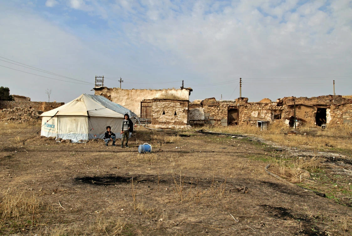 Two boys play outside their tented home in the village of Debaja, west of Mosul, Iraq. (AP)