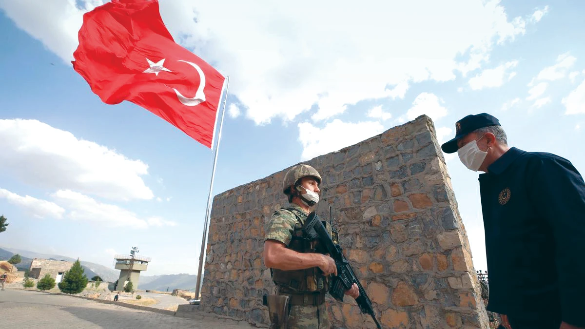 Turkish minister Hulusi Akar speaks to a soldier while visiting near the border with Iraq. Baghdad views Turkey’s raids on the PKK in Iraq as a violation of its sovereignty. (AP)