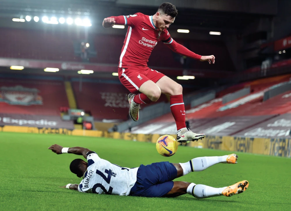 Liverpool’s Andrew Robertson leaps over Tottenham’s Serge Aurier during their English Premier League match at Anfield in Liverpool on Wednesday. (AP)