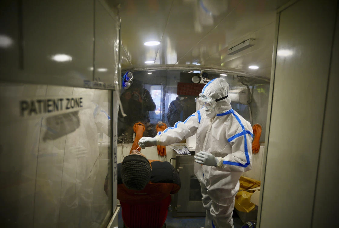 A health worker takes a nasal swab sample to test for COVID-19 inside a mobile testing van in New Delhi, India, Saturday, Dec. 19, 2020. (AP)
