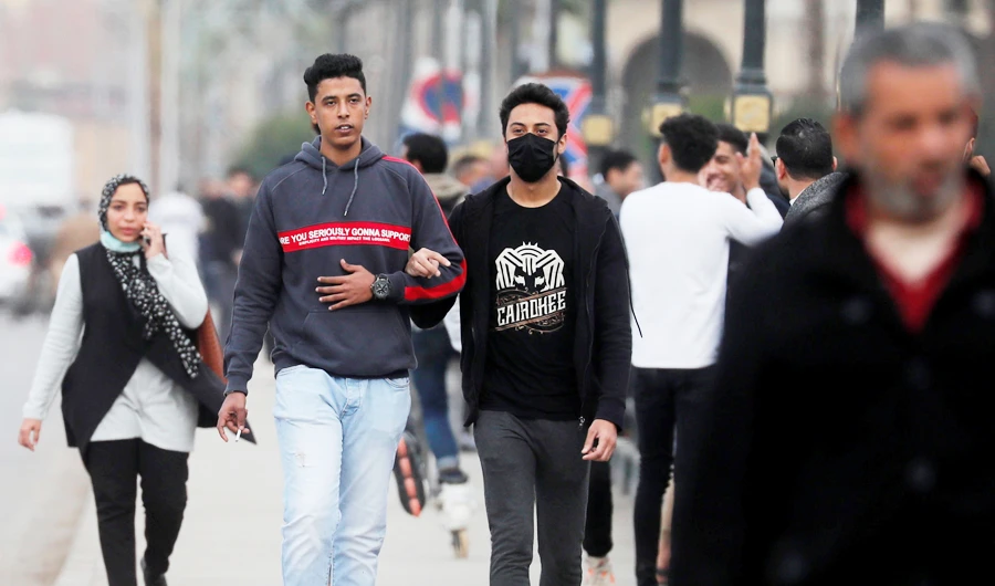 People, some of them wearing protective face masks amid the coronavirus disease (COVID-19) pandemic, walk on Qasr el-Nil bridge leading to Cairo's Tahrir Square, Egypt December 17, 2020. (REUTERS)