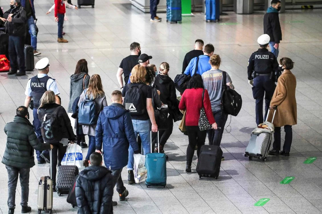 Police escort a group of passengers from the airport's COVID-19 testing center to their gate at Frankfurt International Airport. (AFP)