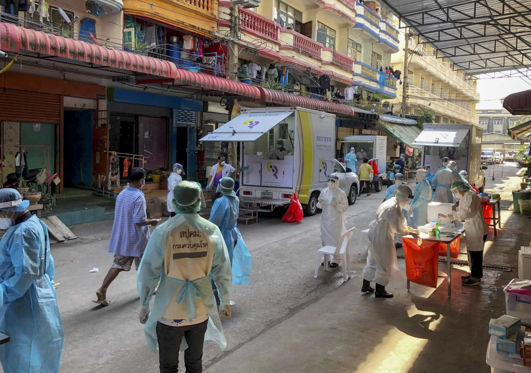 Health workers in protective clothing conduct screening for COVID-19 in Samut Sakhon, south of Bangkok, Thailand, Sunday, Dec. 20, 2020. (AP)