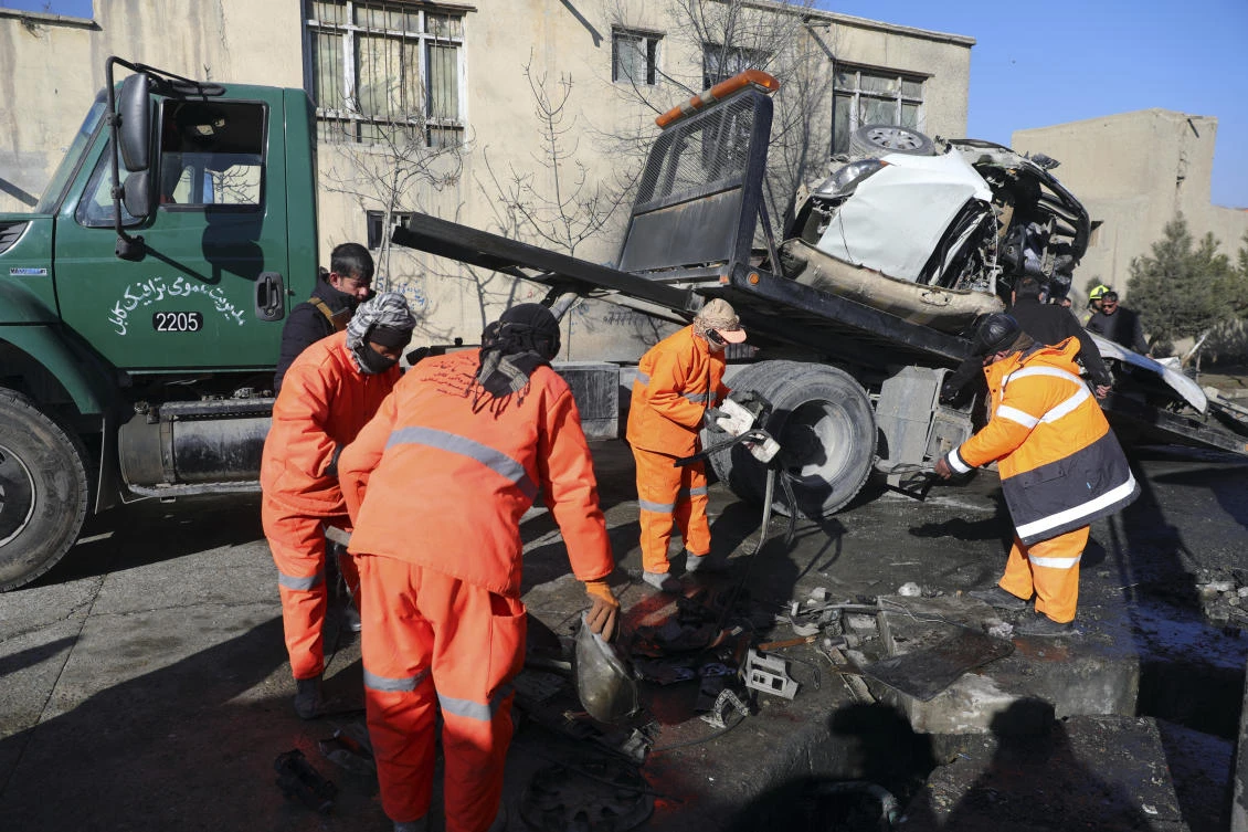 Afghan security personnel and municipality workers remove a damaged vehicle after a roadside bomb attack in Kabul, Afghanistan on Dec. 22, 2020. (AP)