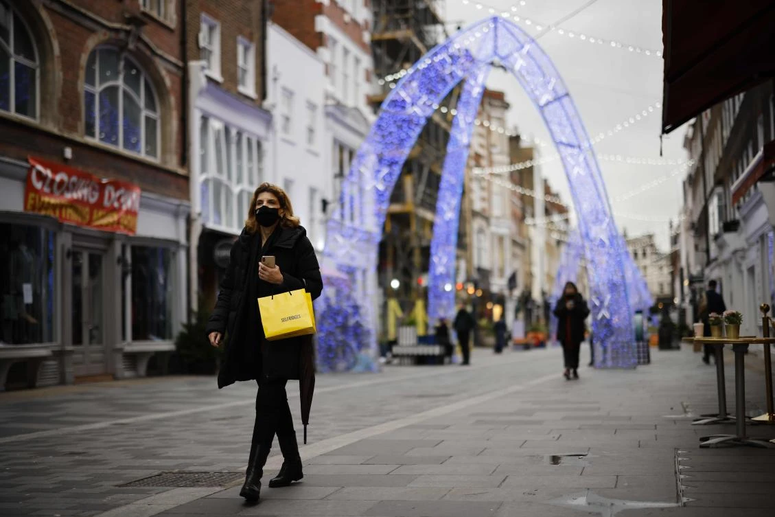 A pedestrian wearing a face mask the COVID-19 pandemic, walks along a street in central London on December 22, 2020. (AFP)