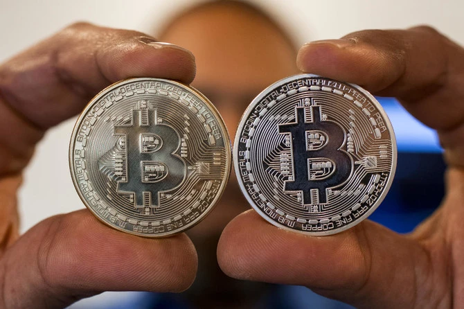 A person holding a visual representation of the digital crypto-currency Bitcoin (Jack Guez /AFP)