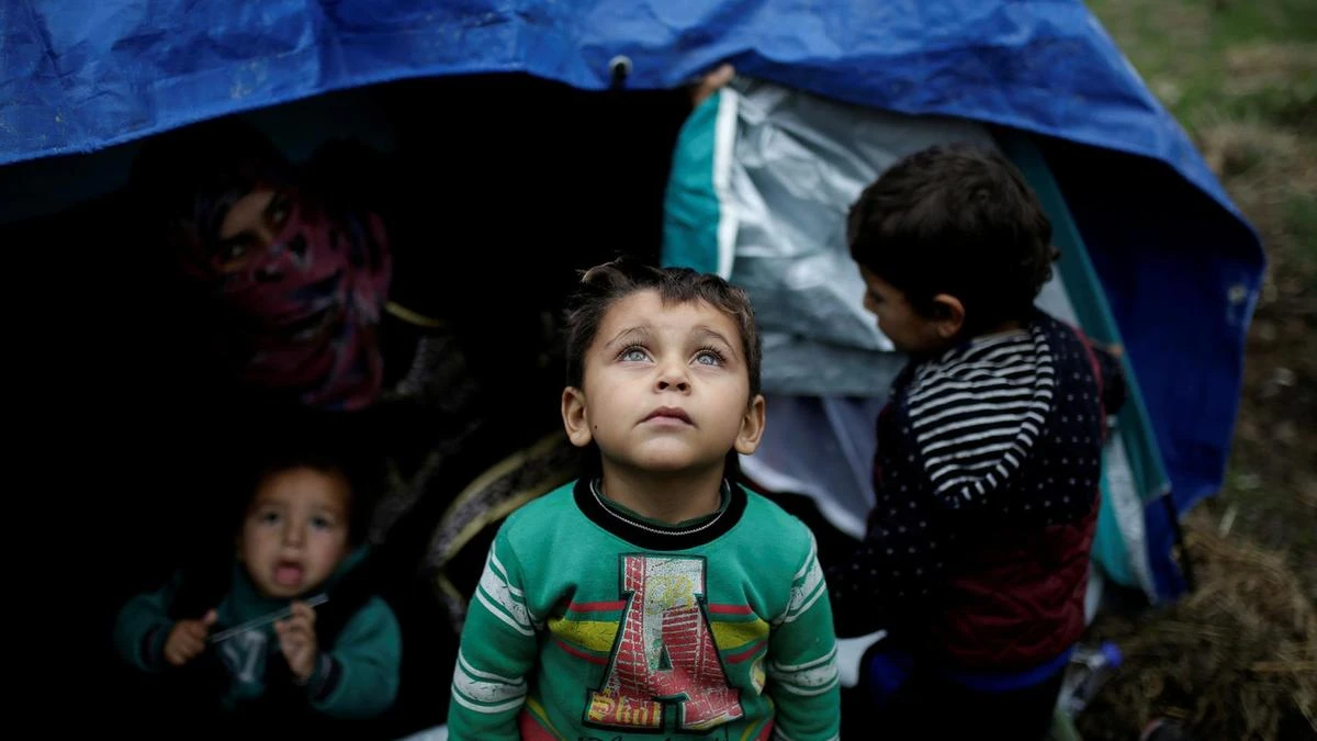 A Syrian refugee boy stands in front of his family tent at the Moria camp on the island of Lesbos, Greece. (Reuters)