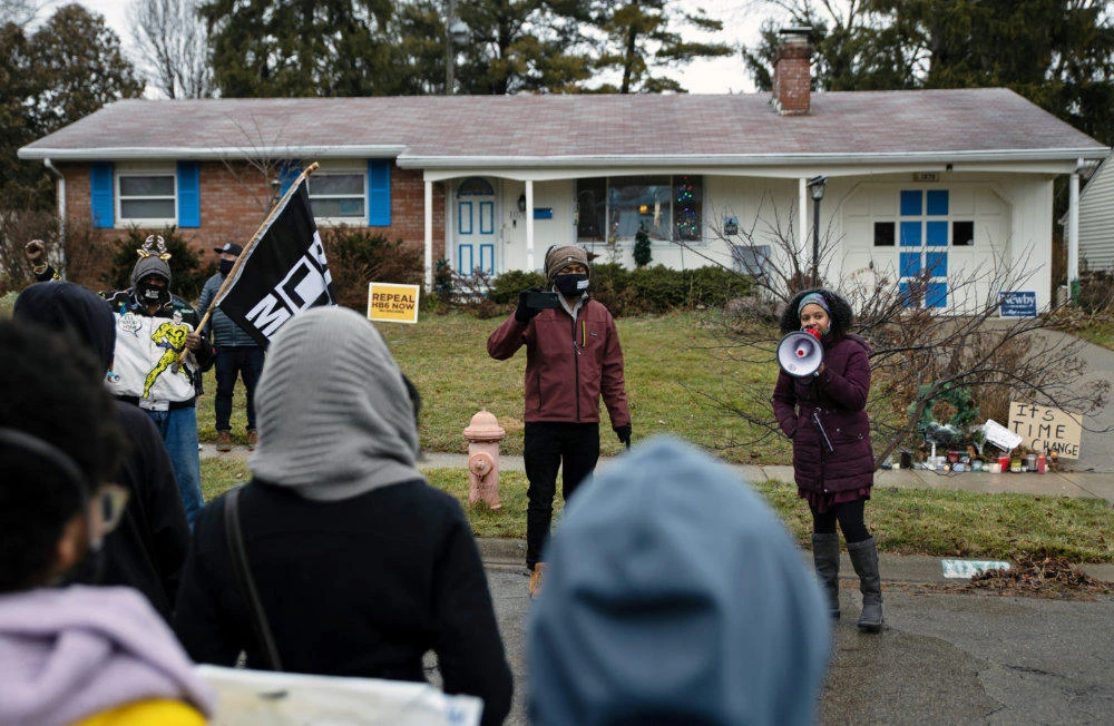 Protesters gather outside the home where Andre Maurice Hill was killed in Columbus, Ohio, on December 24, 2020. (REUTERS/Megan Jelinger)