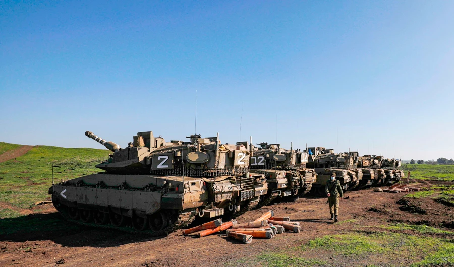Israeli Merkava battle tanks hold position near Moshav Kidmat Tzvi in the Israeli-annexed Golan Heights on Friday. (AFP)