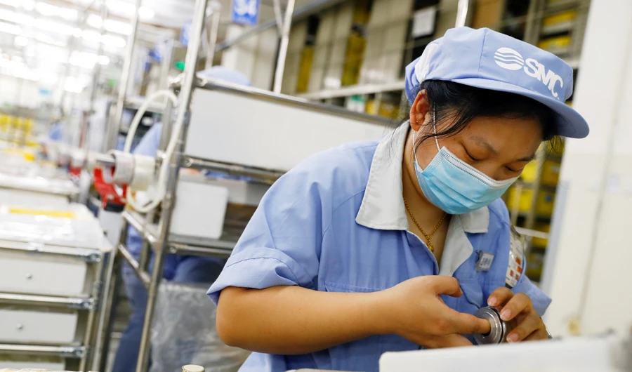 An employee wearing a face mask works at a factory of the component maker SMC during a government organised tour of its facility following the outbreak of the coronavirus disease (COVID-19), in Beijing, China May 13, 2020. (REUTERS)