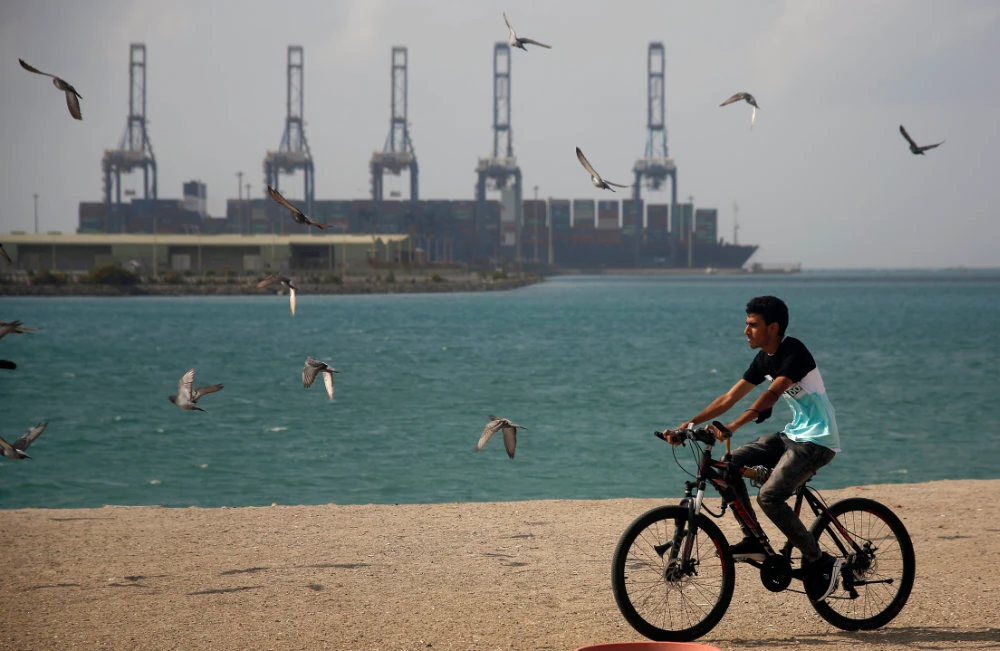 A man rides his bicycle in front of the Jeddah sea port on the Red Sea on Dec. 27, 2020. Saudi Arabia is extending entry into the Kingdom by air, land and sea amid a new coronavirus threat. (AP Photo/Amr Nabil)