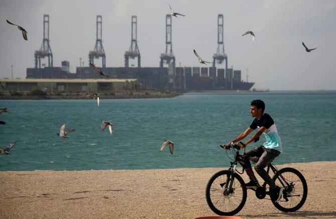 A man rides his bicycle in front of the Jeddah sea port on the Red Sea on Dec. 27, 2020. Saudi Arabia is extending entry into the Kingdom by air, land and sea amid a new coronavirus threat. (AP Photo/Amr Nabil)