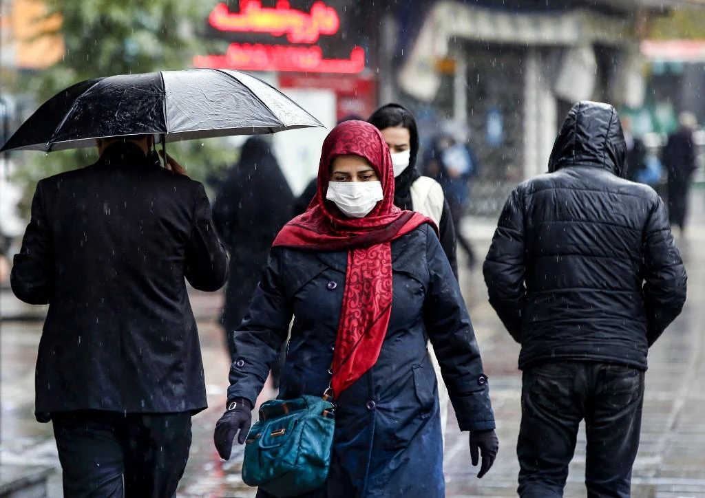 Pedestrians, mask-clad due to the COVID-19 coronavirus pandemic, walk past closed shops along a street in Iran’s capital Tehran on Nov. 21, 2020. (File/AFP)
