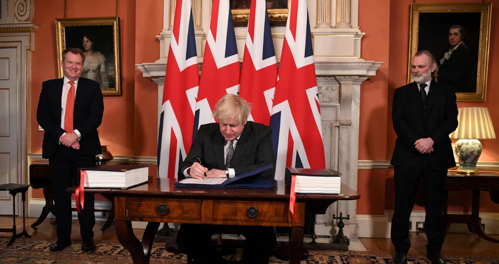 Image Caption : UK chief trade negotiator David Frost and British Ambassador to the EU Tim Barrow look on as Britain's Prime Minister Boris Johnson signs the Brexit trade deal with the EU at number 10 Downing Street in London, Britain December 30, 2020. (Reuters)