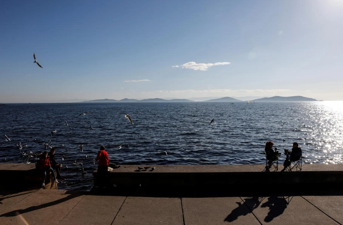 People enjoy a warm and sunny day at the beach amid the spread of the coronavirus disease (COVID-19), in Istanbul, Turkey, December 31, 2020. (Reuters)