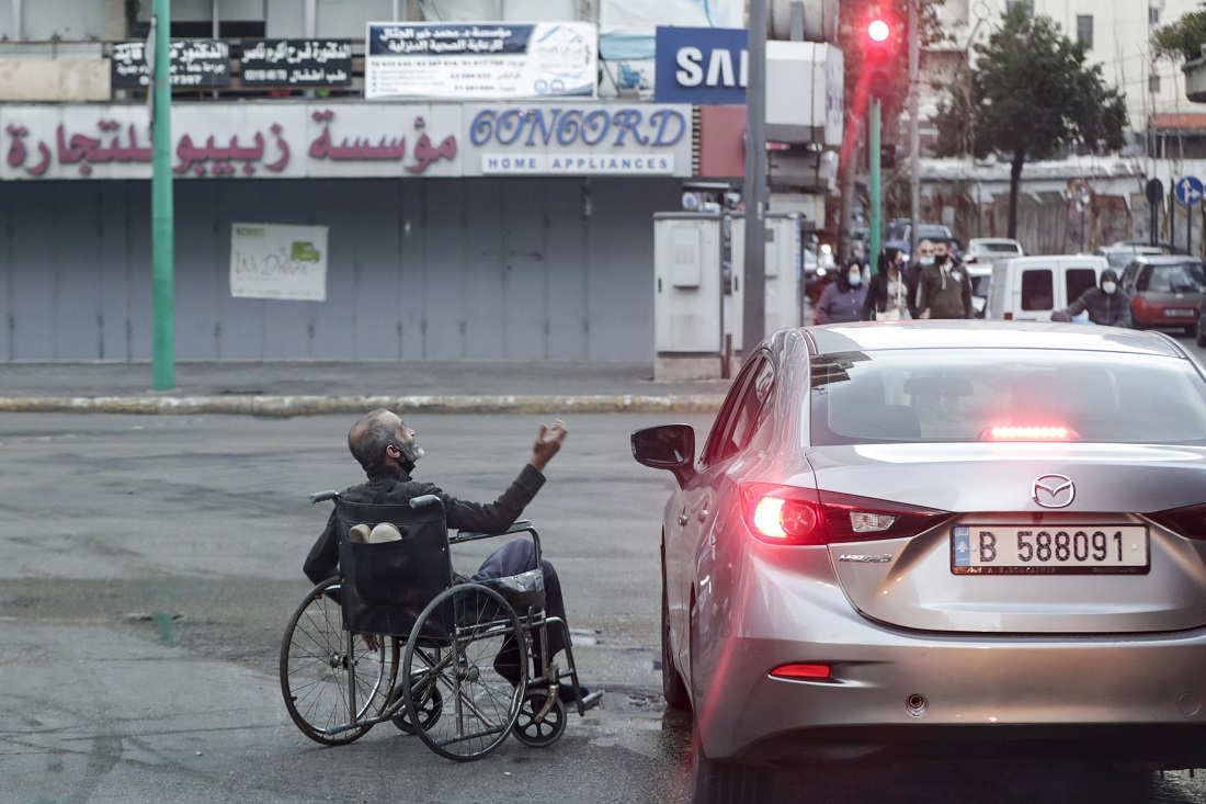A beggar in a wheelchair at a red light on a street in Beirut, January 16, 2021, the Lebanese capital suffers a total lockdown due to the coronavirus pandemic. (Anwar Amro / AFP)
