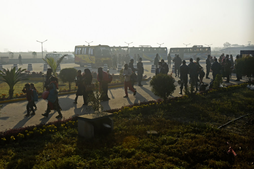 Rohingya refugees walk with their belongings to board a Bangladesh Navy ship in Chittagong on January 29, 2021 as they are being relocated to Bhashan Char Island in the Bay of Bengal. (AFP / Munir Uz zaman)