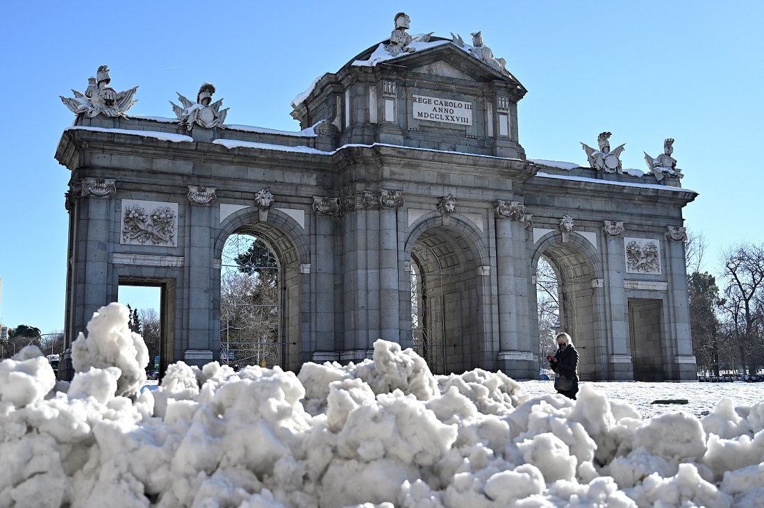A woman walks by Puerta de Alcala after a heavy snowfall in Madrid on Jan. 11, 2021. Schools, courts and museums were closed throughout central Spain for two days after the region was hit with a massive snowstorm. (AFP)