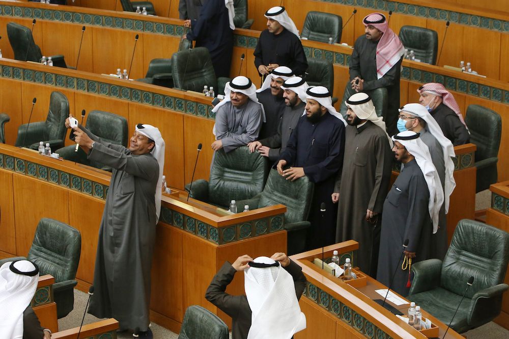 Kuwaiti MP Hamad al-Mutar (L) takes a selfie with fellow MPs after the national assembly session was adjourned due to cabinet's resignation, in Kuwait City on January 19, 2021. (AFP/File Photo)