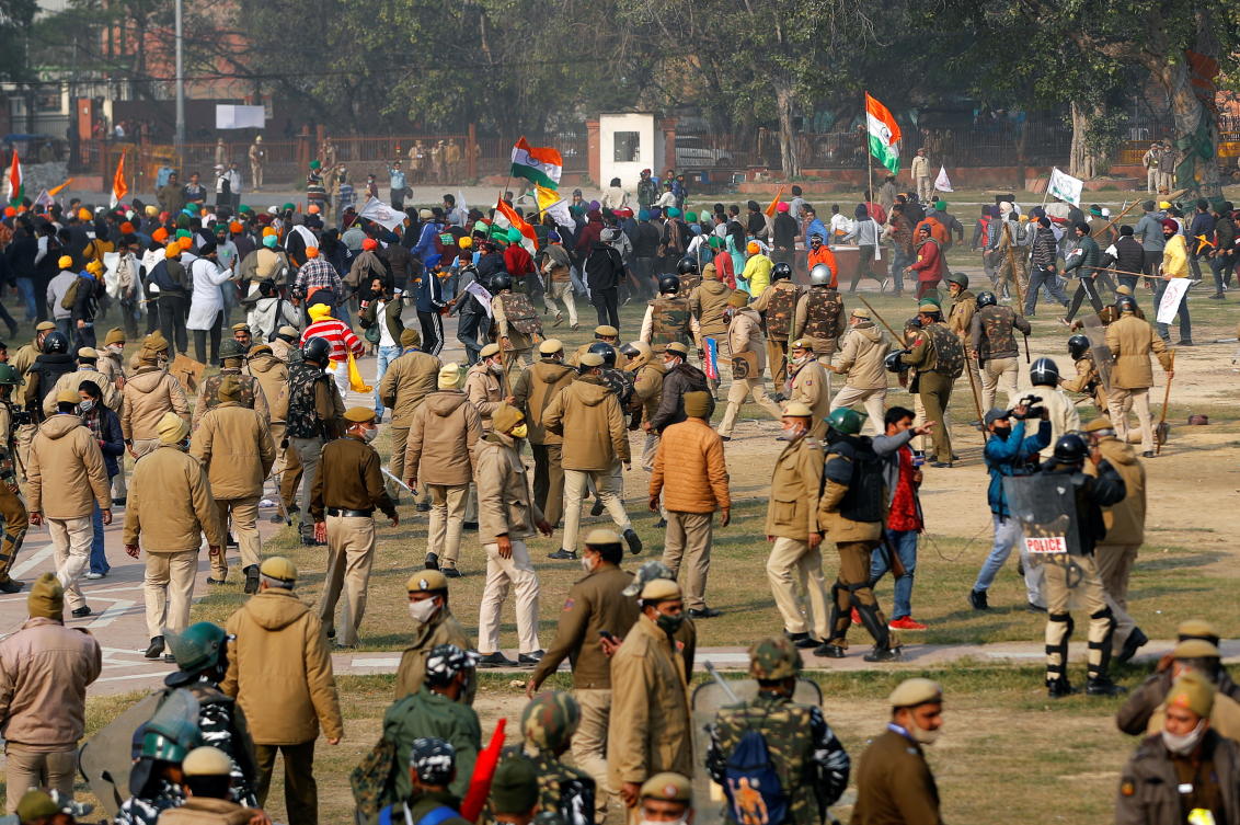 Police officers and farmers are seen during a protest against farm laws introduced by the government, at the historic Red Fort in Delhi, India, January 26, 2021. REUTERS/Adnan Abidi