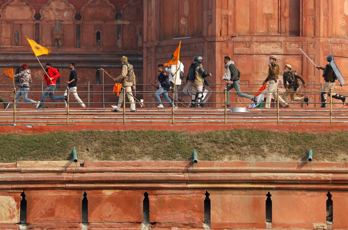 Demonstrators run as police officers chase them during a protest against farm laws introduced by the government, at the historic Red Fort in Delhi, India, January 26, 2021. REUTERS/Adnan Abidi