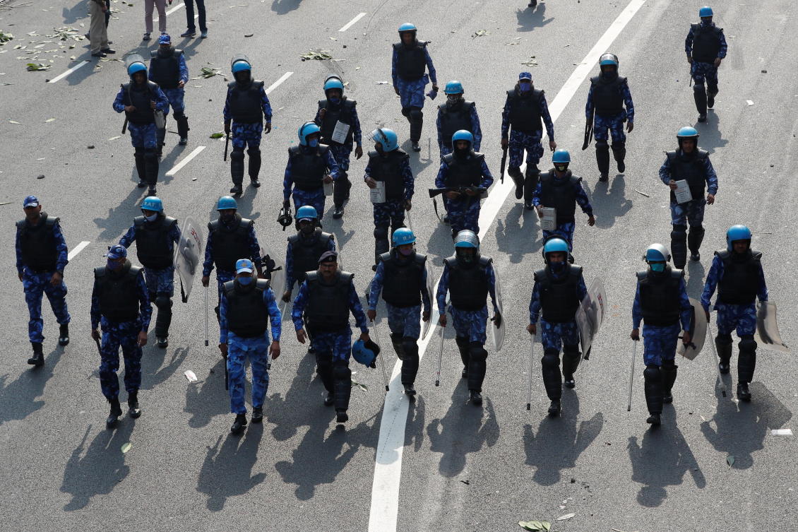 Police officers walk towards farmers during a protest against farm laws introduced by the government, in New Delhi, India, January 26, 2021. REUTERS/Adnan Abidi