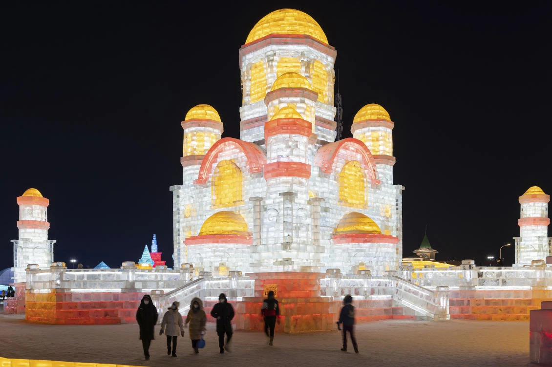 Visitors tour the annual Harbin Ice and Snow World in Harbin in northeast China's Heilongjiang province Tuesday, Jan. 05, 2021. (Chinatopix Via AP)