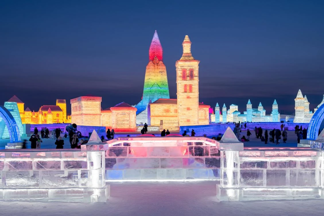 People look at ice sculptures at the Harbin Ice and Snow Festival in Harbin, in northeastern China's Heilongjiang province on January 5, 2021. - China OUT / AFP / STR