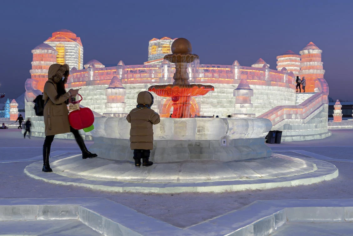 Visitors tour the annual Harbin Ice and Snow World in Harbin in northeast China's Heilongjiang province Tuesday, Jan. 05, 2021. (Chinatopix Via AP)