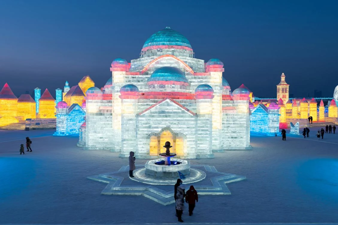 People look at ice sculptures at the Harbin Ice and Snow Festival in Harbin, in northeastern China's Heilongjiang province on January 5, 2021. - China OUT / AFP / STR AND STR