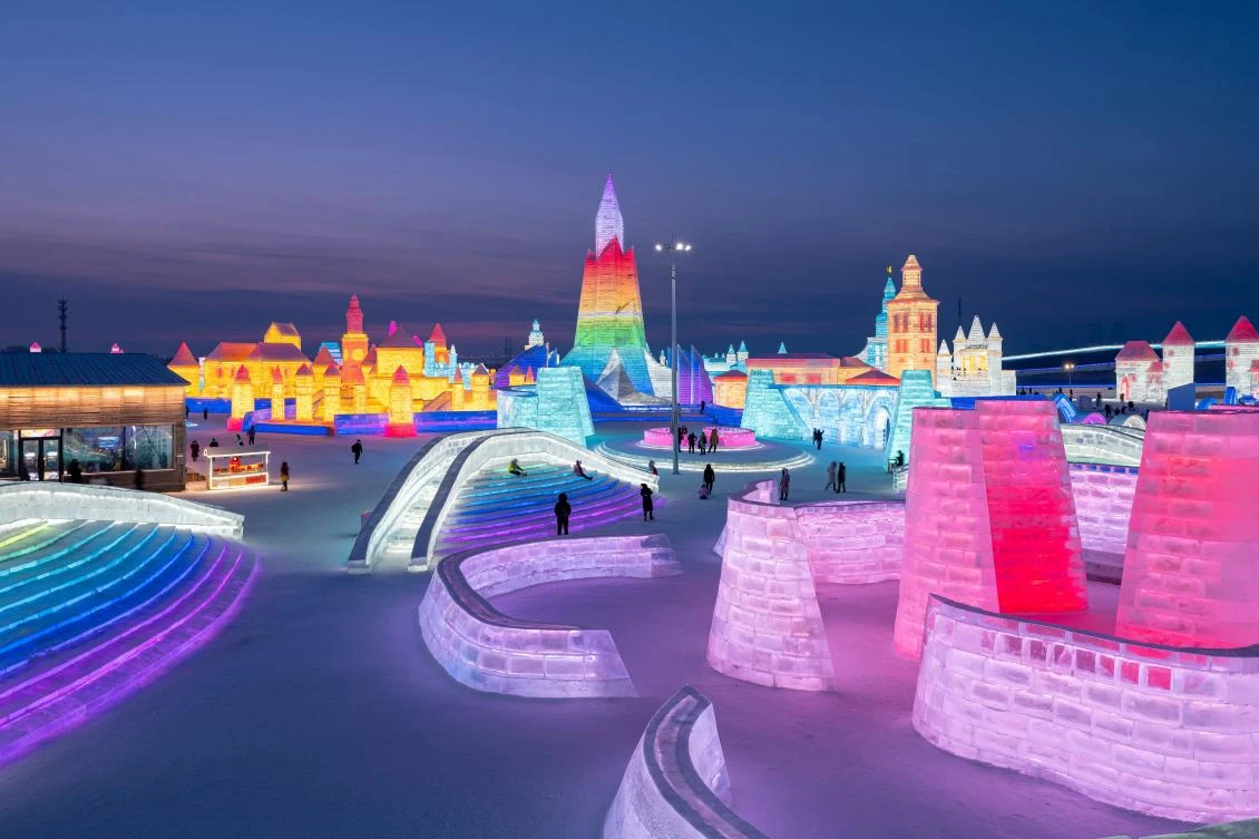 People look at ice sculptures at the Harbin Ice and Snow Festival in Harbin, in northeastern China's Heilongjiang province on January 5, 2021. - China OUT / AFP / STR