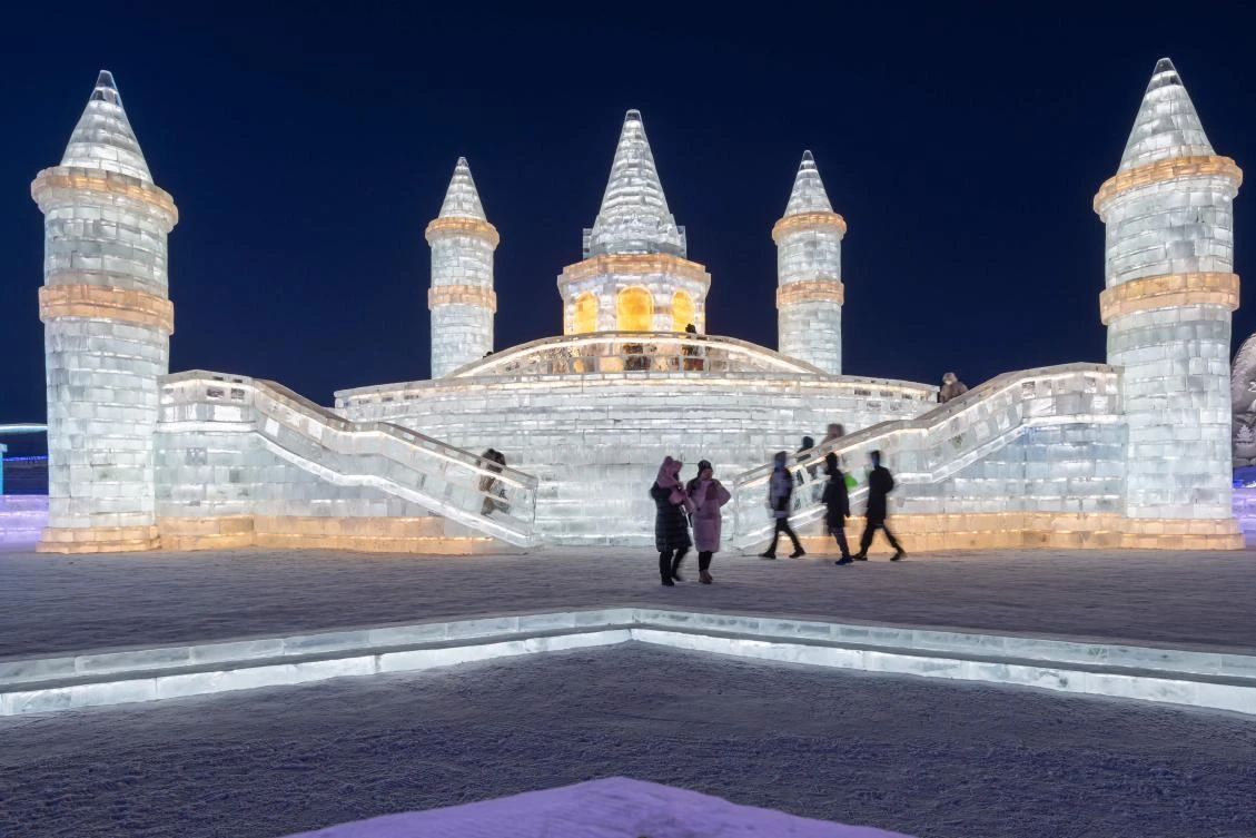 People look at ice sculptures at the Harbin Ice and Snow Festival in Harbin, in northeastern China's Heilongjiang province on January 5, 2021. - China OUT / AFP / STR