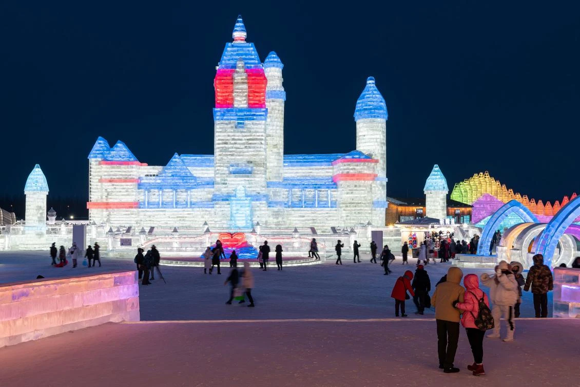 People look at ice sculptures at the Harbin Ice and Snow Festival in Harbin, in northeastern China's Heilongjiang province on January 5, 2021. - China OUT / AFP / STR