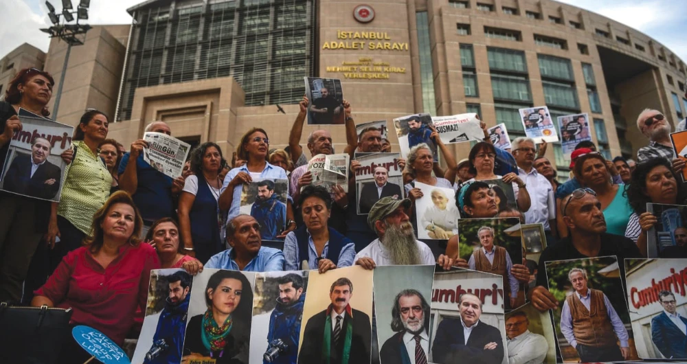 Protesters hold pictures of jailed journalists during a demonstration outside the courthouse in Istanbul. A recent report highlights Turkey’s repeated violations of human rights. (AFP/File)