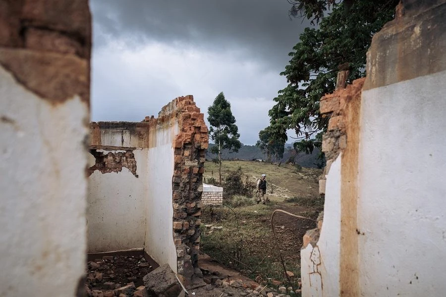 A Pakistani United Nations Organization Stabilization Mission in the Democratic Republic of the Congo (MONUSCO) peacekeeper walk past the ruins of the Bijombo health center destroyed by armed men, South Kivu Province, eastern Democratic Republic of Congo, on October 11, 2020. (File/AFP)