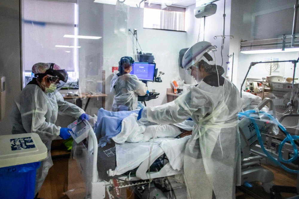 In this file photo taken on December 18, 2020 nurses attend to a Covid-19 patient in the Intensive Care Unit (ICU) at Providence Cedars-Sinai Tarzana Medical Center in Tarzana, California. (AFP / Apu Gomes)