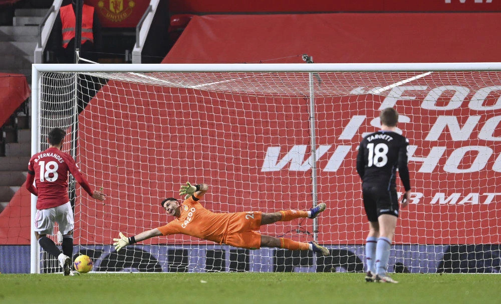 Manchester United's Bruno Fernandes scores from the penalty spot for his sides 2nd goal of the game past a diving Aston Villa's goalkeeper Emiliano Martinez during the English Premier League soccer match between Manchester United and Aston Villa at Old Trafford in Manchester, England, on Jan. 1, 2021. (Lawrence Griffiths/ Pool via AP)
