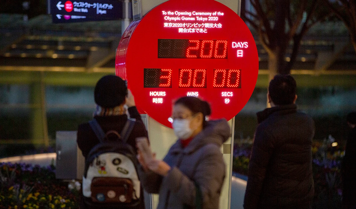 People walk by a countdown calendar showing 200 days to the opening ceremony of the Tokyo 2020 Olympics Monday, Jan. 4, 2021, in Tokyo. (AP)