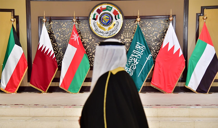(FILES) A man walks past the flags of the countries attending the Gulf Cooperation Council (GCC) summit at Bayan palace in Kuwait City on December 5, 2017. (AFP)