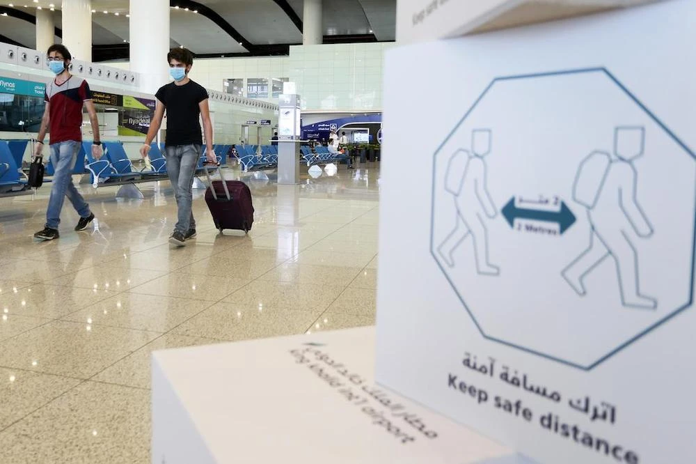 Travelers wearing protective face masks walk at Riyadh International Airport, after Saudi Arabia reopened domestic flights in Riyadh, Saudi Arabia. (File/Reuters)